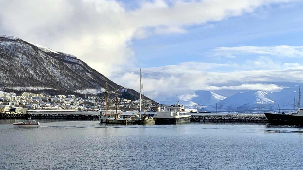 Hafen von Tormsø mit Sicht auf die frisch verschneiten Berge